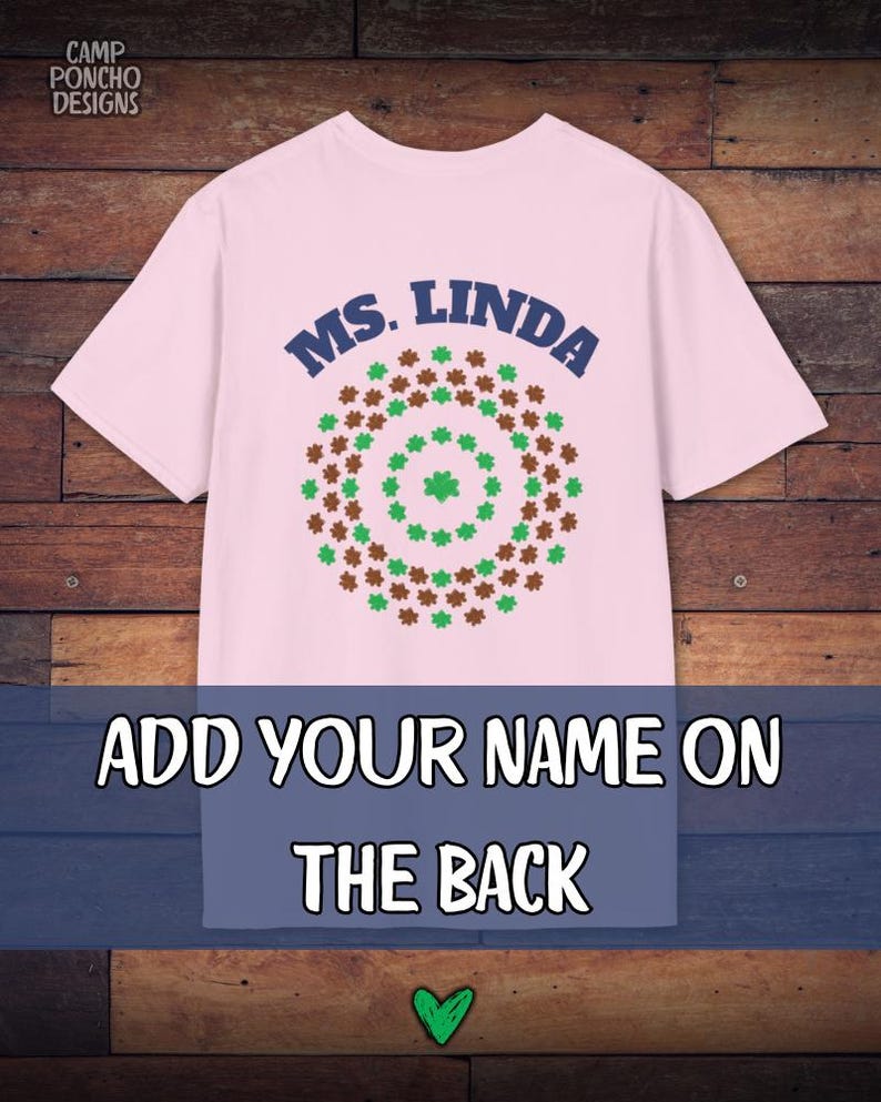 May include: A light pink t-shirt with the text "MS. LINDA" in navy blue above a circular design of green and brown shamrocks. Below, the text "ADD YOUR NAME ON THE BACK" is displayed. The Camp Poncho Designs logo is in the top left corner.