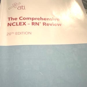 May include: A textbook titled "The Comprehensive NCLEX - RN Review" with the ATI logo at the top. The cover is white with red text and a blue lower section. The edition is the 20th.