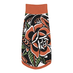 May include: A dog tank top with a tattoo-style rose design. The top features a burnt orange collar and trim, with a large rose in shades of orange, black, and white. Green leaves and black swirls complete the design.