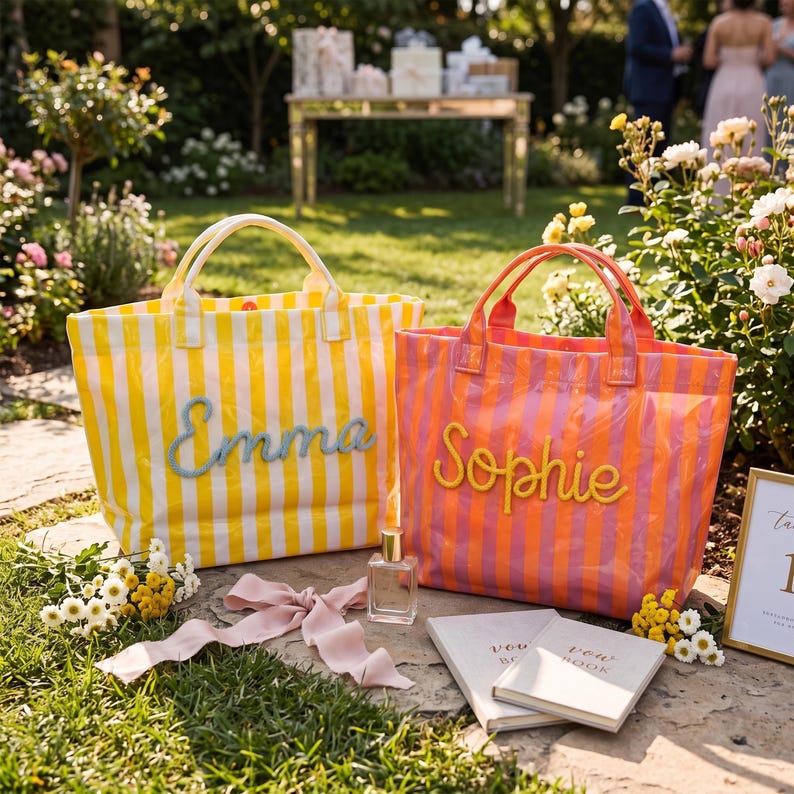 May include: Two rectangular tote bags with vertical stripes. The left bag is yellow and white with the name Emma in blue script. The right bag is orange and pink with the name Sophie in yellow script. Both bags feature two top handles.