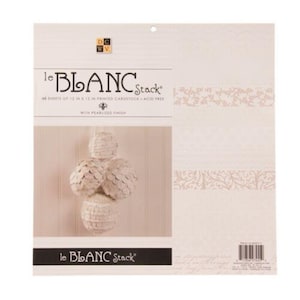 May include: A package of "le BLANC Stack" printed cardstock paper. The package is white with decorative borders and a hanging ornament. The text on the package reads "48 sheets of 12 in x 12 in printed cardstock - acid free".