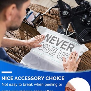 May include: A white t-shirt with the words "NEVER GIVE UP" printed in gray. The shirt is being pressed with a heat press machine. The image also includes the text "NICE ACCESSORY CHOICE".