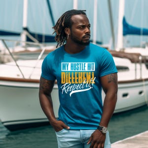 May include: A teal crew neck t-shirt with the text "MY HUSTLE HIT DIFFERENT! Respect it!" in white, yellow, and orange. The shirt is worn by a person with dreadlocks, standing near a boat.