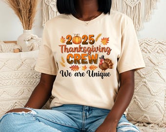 May include: Beige t-shirt with the text "2025 Thanksgiving CREW We are Unique" in orange, brown, and black. The design includes a pumpkin, leaves, and a turkey wearing a pilgrim hat. The model is wearing blue jeans.