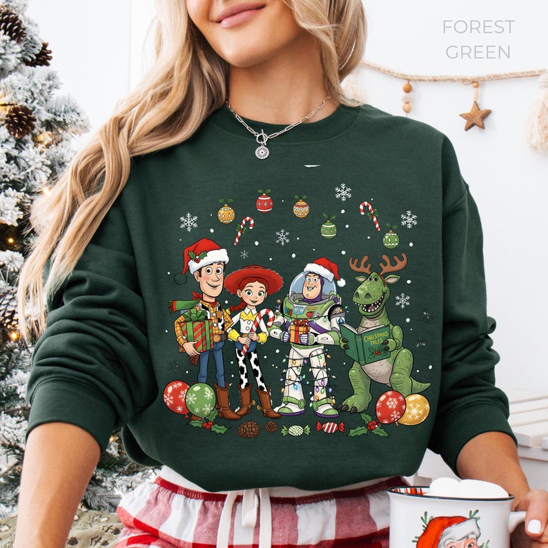 A woman wearing a green sweatshirt with a Christmas-themed graphic of characters from the Toy Story movie, including Woody, Buzz Lightyear, and a dinosaur.