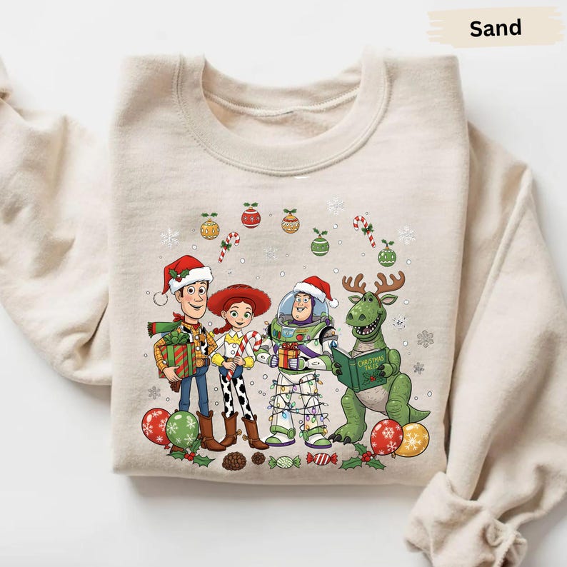 A beige sweater with a Christmas-themed graphic design featuring characters from the Toy Story franchise, including Woody, Buzz Lightyear, and a dinosaur.