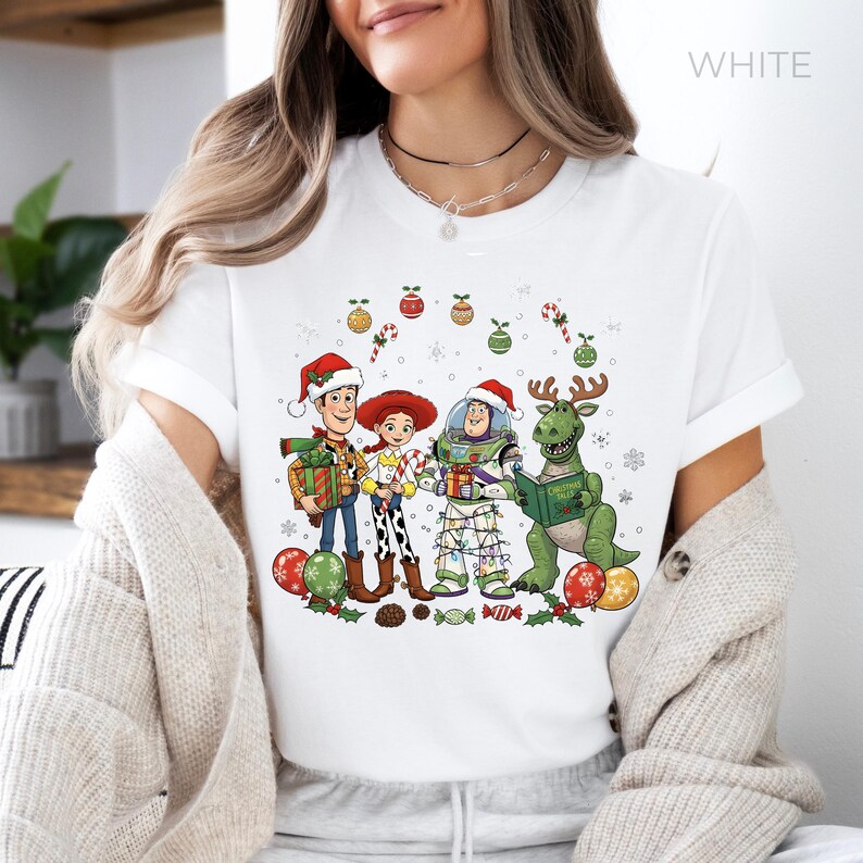 A woman wearing a white t-shirt with a Christmas-themed graphic design featuring characters from the Toy Story franchise.