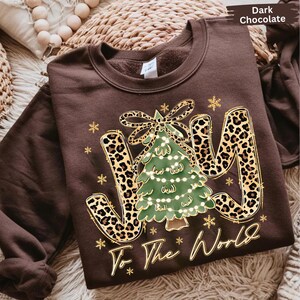 A brown sweatshirt with a Christmas tree design and the text "Joy To The World" printed on it.