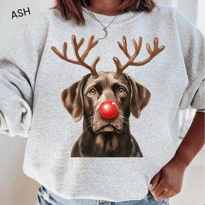 A gray sweatshirt with a graphic of a dog wearing a red nose and antlers, resembling a reindeer.