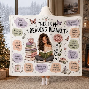 May include: A white fleece blanket featuring the text THIS IS MY READING BLANKET, an illustration of a person reading a book, a stack of books, a flower, and various speech bubbles with phrases like One more chapter and My weekend is fully booked.