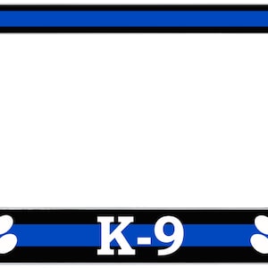 Puede incluir: Marco cromado para matrícula con una franja azul y el texto "K-9". El marco tiene huellas de patas blancas sobre un fondo negro. La parte superior e inferior del marco tienen una franja azul.