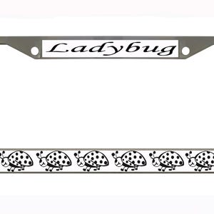 May include: A silver license plate frame with the word "Ladybug" in black script at the top. The bottom of the frame features a repeating pattern of black and white ladybug illustrations.
