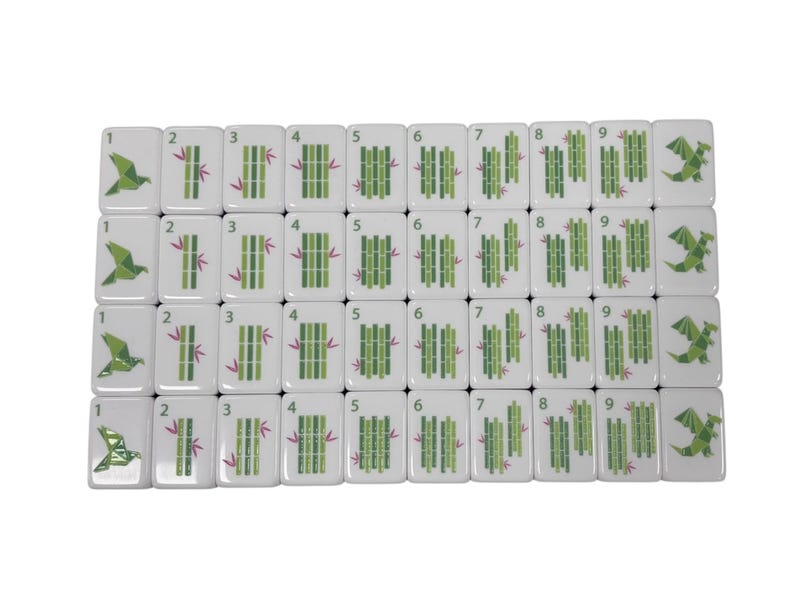 May include: A set of white Mahjong tiles with green bamboo and dragon illustrations. Each tile displays a number from 1 to 9. The tiles are arranged in rows and columns, showcasing the variety of designs.