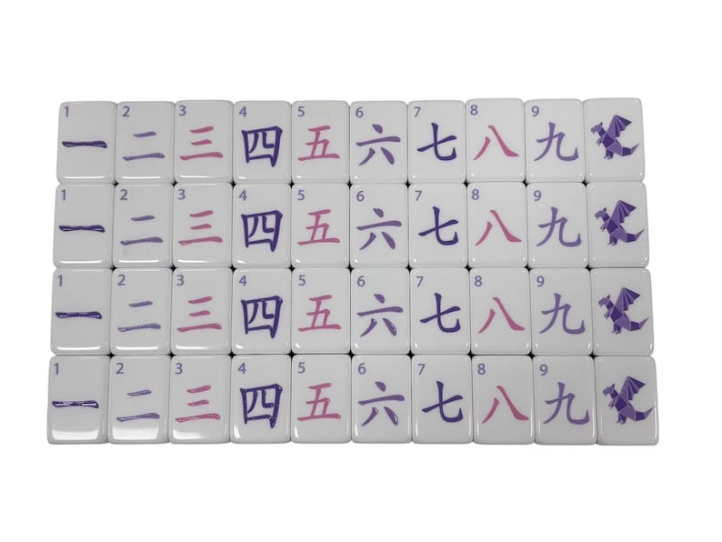 May include: A set of white Mahjong tiles arranged in rows. Each tile features a number from one to nine in both Arabic numerals and Chinese characters, along with a purple dragon symbol. The numbers are in purple and pink.