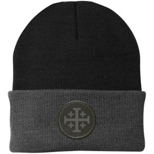 May include: A black and grey beanie hat. The top section is black, and the folded brim is grey. A circular patch on the brim features a grey Jerusalem cross design. The hat is made of a knitted material.