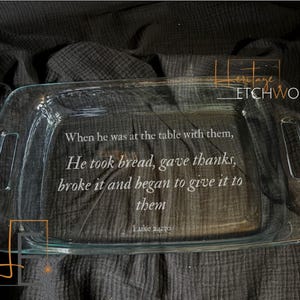 May include: A clear glass rectangular baking dish with handles. The dish has etched text that reads, "When he was at the table with them, He took bread, gave thanks, broke it and began to give it to them. Luke 24:30."