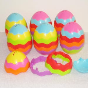 May include: Set of eight colorful plastic Easter eggs with a wavy design. The eggs are open and can be used for hiding small treats or toys.