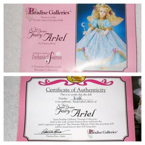 May include: A pink box with the text "Paradise Galleries" and "The Sweet Dreams Fairy Ariel" is shown. A certificate of authenticity for the doll is also visible, with the artist's signature and the text "Premiere Edition".