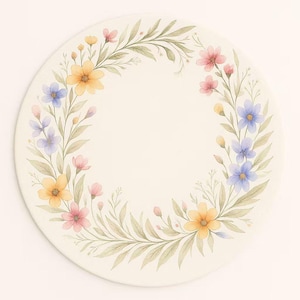 May include: A round, off-white plate with a watercolor floral design. The design features a wreath of yellow, pink, and blue flowers with green leaves. The plate has a smooth surface and a simple, elegant aesthetic.