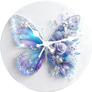 May include: A round wall clock featuring a butterfly design. The butterfly has blue, purple, and white wings with floral accents. The clock hands are white, and the background is white.