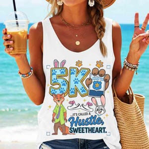 May include: White tank top with a colorful graphic design featuring the text "5K" and cartoon characters. The design includes a fox, a bunny, paw prints, and the phrase "...It's called a Hustle, Sweetheart."