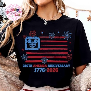 May include: Black t-shirt featuring a stylized American flag design with red and blue stripes and fireworks. The flag incorporates a Mickey Mouse-themed logo in the upper left corner. Text reads "250th America Anniversary 1776-2026."