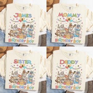 K&ouml;nnte beinhalten: Vier cremefarbene T-Shirts mit Geburtstagsmotiven. Ein Shirt tr&auml;gt die Aufschrift "JAMES" mit der Zahl "5", ein anderes "MOMMY", ein drittes "SISTER" und das letzte "DADDY". Jedes Shirt hat eine farbenfrohe Grafik von Zeichentieren und den Worten "BIRTHDAY BOY".