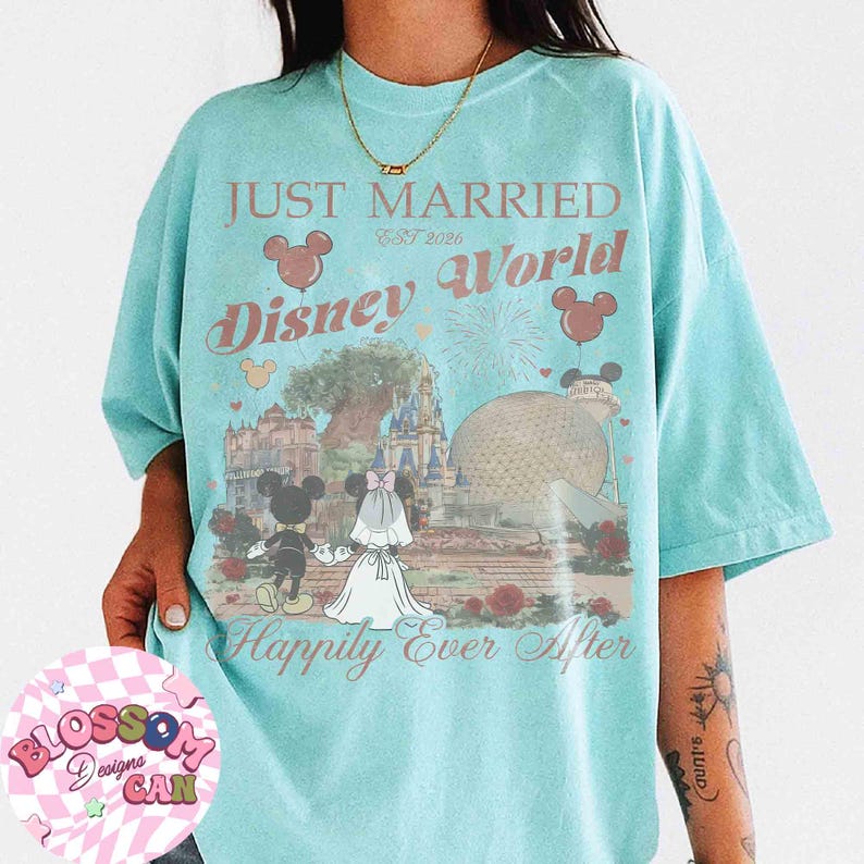 May include: A light blue t-shirt with the text "JUST MARRIED Disney World Happily Ever After" and a graphic of Mickey and Minnie Mouse in wedding attire. The design includes iconic Disney World landmarks and fireworks.