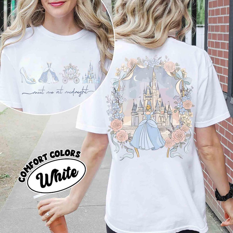 May include: White Comfort Colors t-shirt featuring a Cinderella theme. The front displays a shoe, dress, carriage, and castle with the text "meet me at midnight." The back showcases Cinderella in a blue gown in front of a castle, surrounded by flowers.