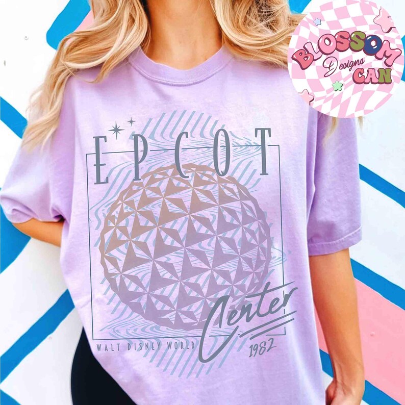 May include: A light purple t-shirt with the text "EPCOT Center" and a graphic of the EPCOT ball. The shirt also includes the text "Walt Disney World 1982". The shirt has short sleeves.