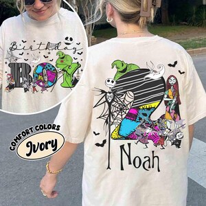 May include: An ivory t-shirt featuring a large graphic of the number 2 filled with colorful patterns, surrounded by characters from The Nightmare Before Christmas, including Jack Skellington, Sally, and Oogie Boogie, with the name Noah printed below.