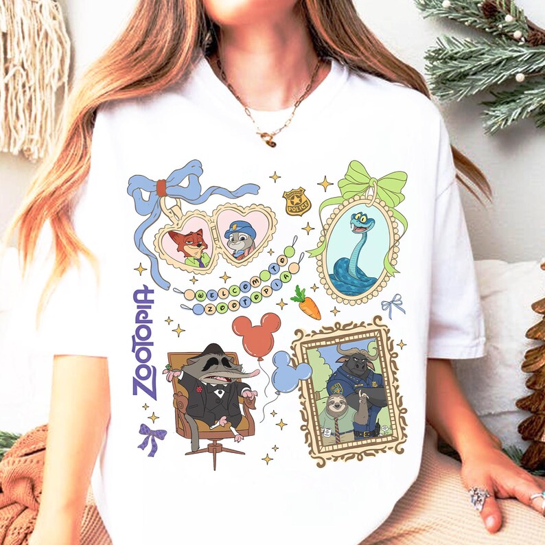 以下が含まれることがあります： アニメ映画「ズートピア」のカラフルなイラストが描かれた白いTシャツ。ニック・ワイルドやジュディ・ホップスなどのキャラクターと、紫色の「Zootopia」の文字がデザインされています。Tシャツはクルーネックです。