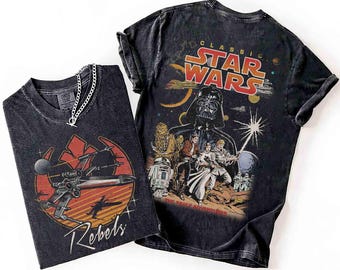 May include: Two black graphic t-shirts featuring Star Wars designs. One shirt displays the text "Rebels" with a red and orange graphic of a spaceship. The other shirt has "Classic Star Wars" text and a graphic of Darth Vader and other characters.