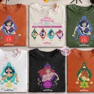 May include: A collection of six t-shirts featuring Disney Princesses. Each shirt has a different princess graphic, including Snow White, Jasmine, and Ariel, with event details like "Princess Half Marathon Weekend" and "10K" and "5K" runs. The shirts come in various colors.