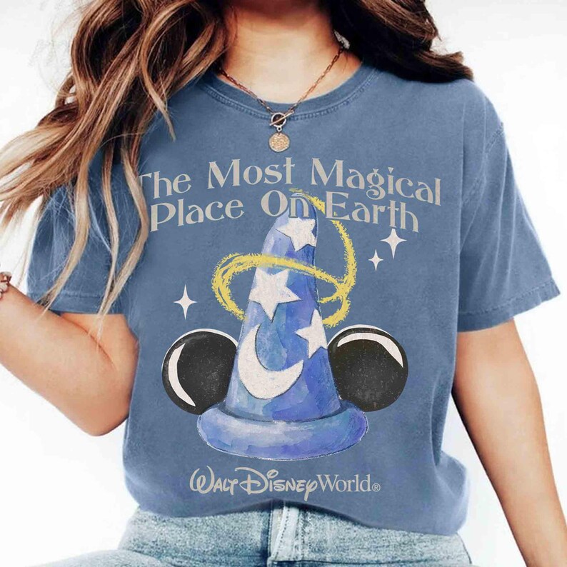 May include: Blue t-shirt featuring the text "The Most Magical Place On Earth" and a wizard hat graphic with stars and Mickey Mouse ears. The Walt Disney World logo is at the bottom.