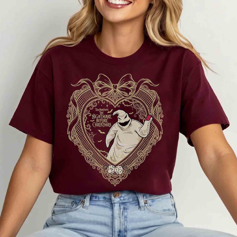 May include: Burgundy crew neck t-shirt featuring a heart-shaped design with the text "The Burton's Nightmare Before Christmas". The design includes an illustration of Oogie Boogie and dice.