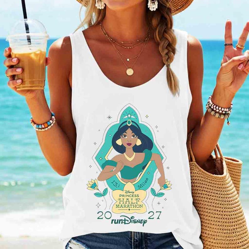 May include: White tank top featuring a graphic of Princess Jasmine from Disney's Aladdin, running. The design includes the text "Disney Princess Half Marathon" and "runDisney". The tank top is sleeveless.