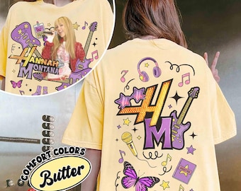 May include: Butter yellow t-shirt with a graphic of a singer, guitars, musical notes, and the text "Hannah Montana". The back of the shirt features the "HM" logo, headphones, stars, and a butterfly. The shirt is a Comfort Colors brand.