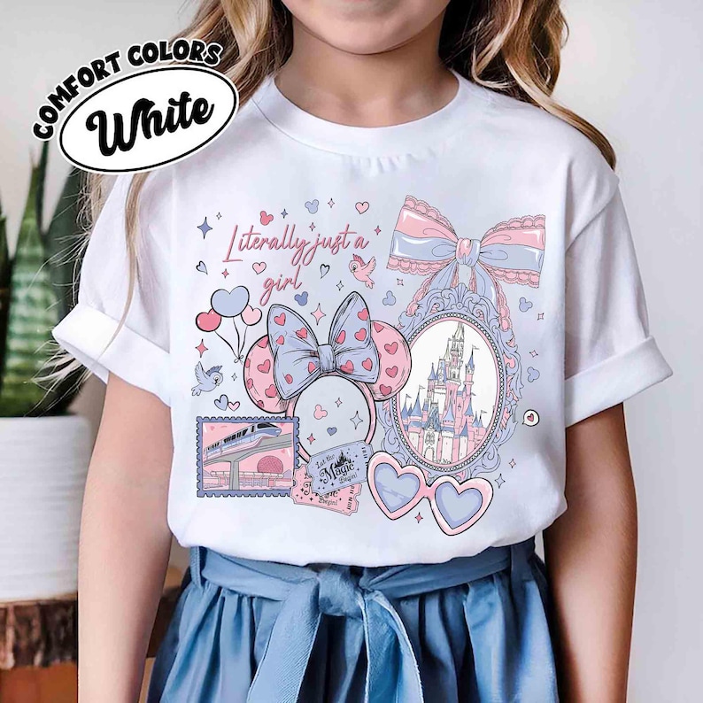 Puede incluir: Camiseta blanca Comfort Colors con un dise&ntilde;o gr&aacute;fico que presenta un castillo, gafas en forma de coraz&oacute;n y el texto "Literally just a girl". El dise&ntilde;o incluye lazos, corazones y un billete de tren.