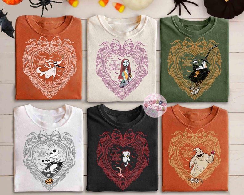 May include: Six t-shirts in various colors, each featuring a heart-shaped design with characters from "The Nightmare Before Christmas." The designs include Zero, Sally, Jack Skellington, and Oogie Boogie. The shirts are orange, white, green, black, and white.