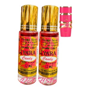 Op de afbeelding: Twee parfumflesjes met gouden doppen en rode vloeistof. De etiketten luiden "Have a Scent Collection" en "YARA Candy Pour Femme 12 ml." Een derde, kleiner roze flesje is ook zichtbaar, met gouden accenten en de naam "Yara Candy."