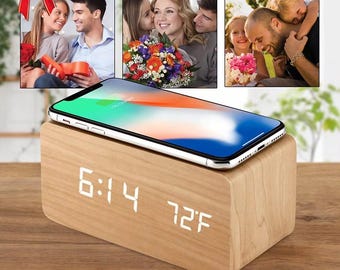 May include: A wooden digital alarm clock with a smartphone on top. The clock displays the time as 6:14 and the temperature as 72°F. The image includes the text "IDEAL GIFT for your loved ones!"