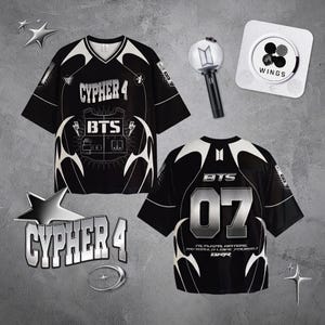 Puede incluir: Camiseta negra y blanca con texto "CYPHER 4" y "BTS". La camiseta tiene cuello en V y el número "07" en la espalda. También se ven un light stick y un botón "WINGS".
