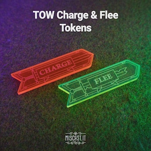 Könnte beinhalten: Zwei Spielmarken aus Acryl mit dem Text "TOW Charge & Flee Tokens". Eine Marke ist orange und trägt die Aufschrift "CHARGE", die andere ist grün und trägt die Aufschrift "FLEE". Beide Marken haben ein Schwertdesign und liegen auf einer grünen Oberfläche.