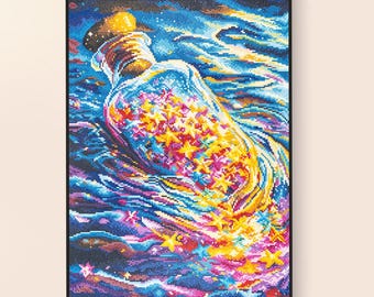 Könnte beinhalten: Ein lebendiges, gerahmtes Kunstwerk zeigt eine Glasflasche voller bunter Sterne. Die Flasche, mit einem goldenen Verschluss, ist vor einem wirbelnden Hintergrund aus Blau-, Lila- und Rosatönen platziert und erzeugt eine verträumte, himmlische Szene. Das Kunstwerk ist eine Kreuzsticharbeit.