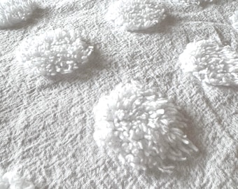 Puede incluir: Tela blanca texturizada con un patrón repetitivo de círculos blancos en relieve.