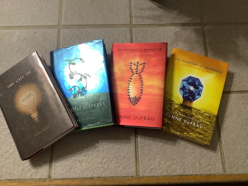 Puede incluir: Se muestran cuatro libros de tapa dura con cubiertas coloridas. Los t&iacute;tulos incluyen "The City Of", "People of Sparks", "The Prophet of Yonwood" y "The Diamond of Darkhold". Los libros son de Jeanne DuPrau.