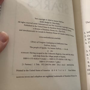 Puede incluir: P&aacute;ginas de libro abierto con informaci&oacute;n de derechos de autor, incluido el t&iacute;tulo "The people of Sparks" de Jeanne DuPrau. El texto incluye n&uacute;meros ISBN y un resumen de la trama del libro. El libro es una primera edici&oacute;n, impreso en los Estados Unidos.