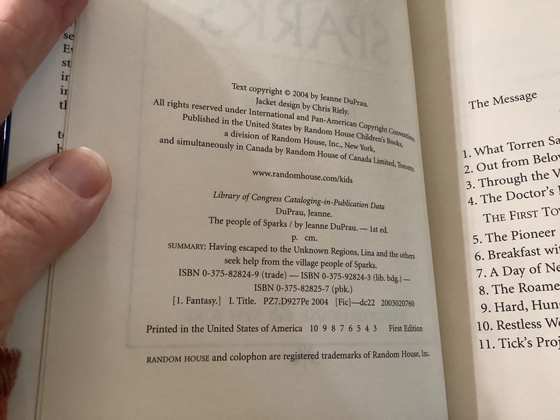 Puede incluir: P&aacute;ginas de libro abierto con informaci&oacute;n de derechos de autor, incluido el t&iacute;tulo "The people of Sparks" de Jeanne DuPrau. El texto incluye n&uacute;meros ISBN y un resumen de la trama del libro. El libro es una primera edici&oacute;n, impreso en los Estados Unidos.