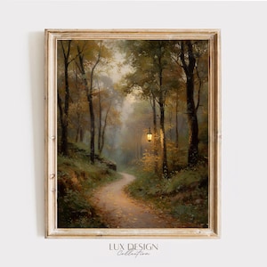 Può includere: Una stampa artistica da parete incorniciata che raffigura un sentiero nel bosco in autunno con alberi alti, foglie cadute e una lanterna luminosa appesa a un ramo. La scena presenta toni caldi dorati e marroni, nebbia soffusa e il testo LUX DESIGN Collection.